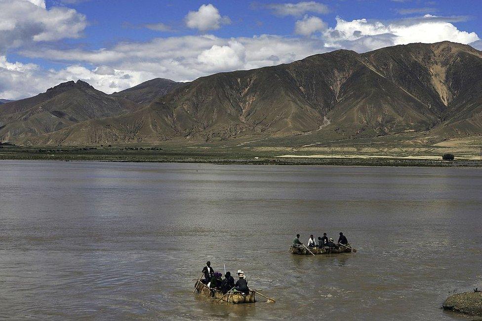 Tibetan people row cowskin rafts on the Brahmaputra River on August 30, 2006 in Renbu County of Tibet Autonomous Region, China. Cowskin is a traditional material used to make rafts for fishing and to cross rivers and lakes for the Tibetan people.