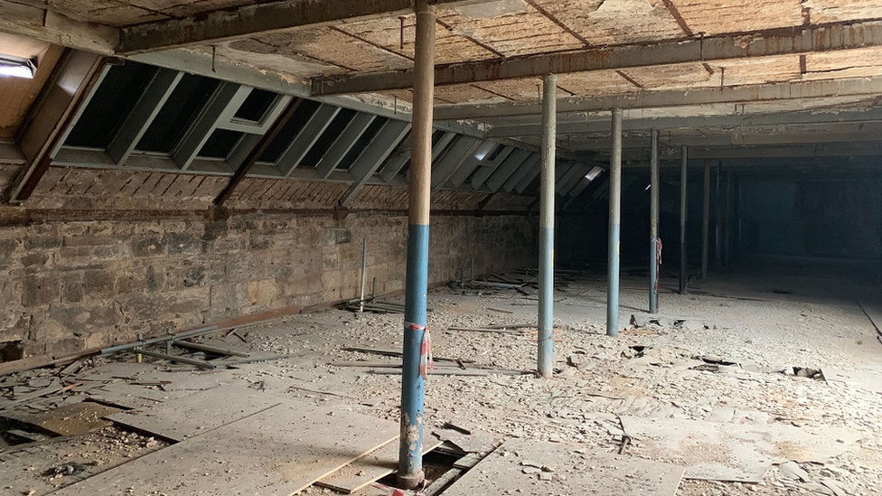 A shot of the interior. The floor is dirty with supporting columns for the roof