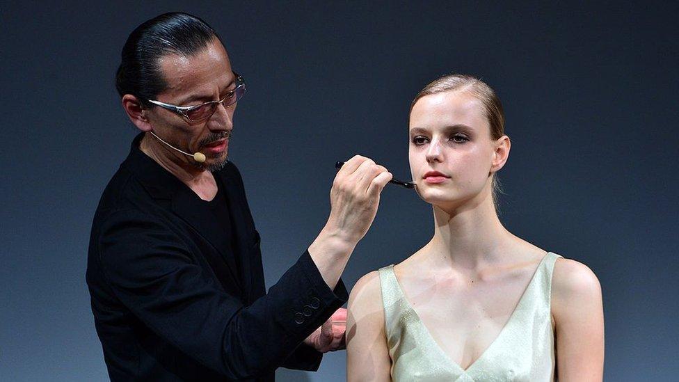 A make-up artist with Japanese cosmetics maker Shiseido applies make-up on a model during a demonstration in Tokyo