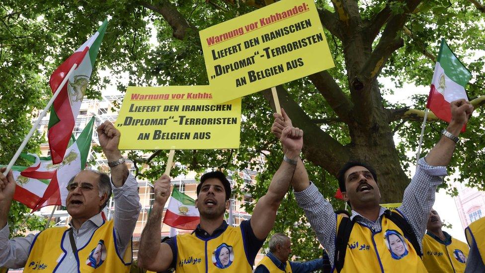 activists of the National Council of Resistance of Iran (NCRI) hold placards reading "Deliver the Iranian diplomat - terrorist to Belgium" during a demonstration calling for the extradition of a secret service officer to Belgium in front of the Federal Foreign Office in Berlin