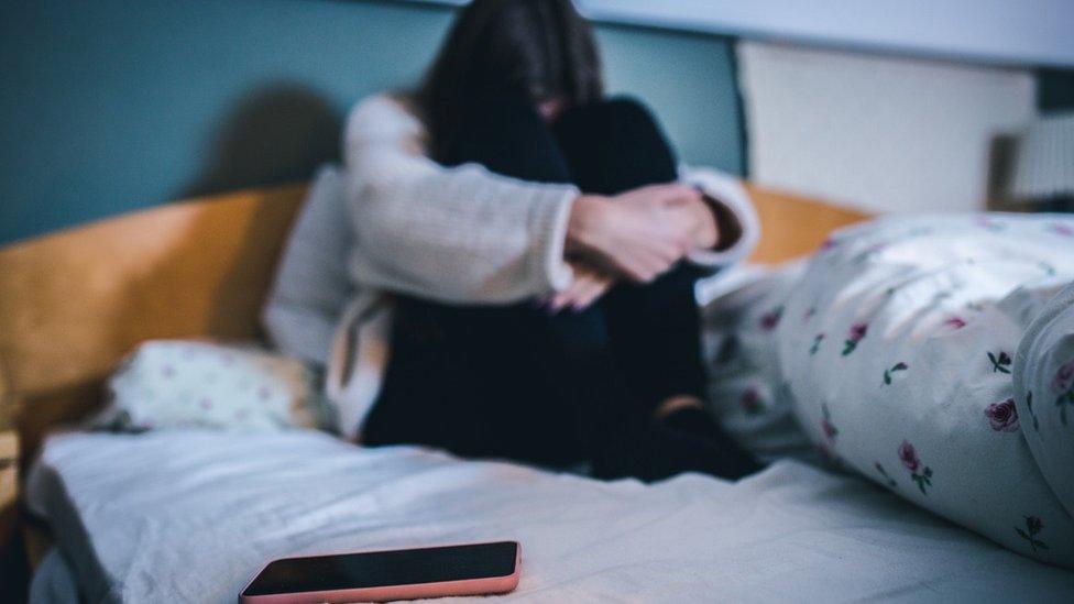 Child on bed with phone