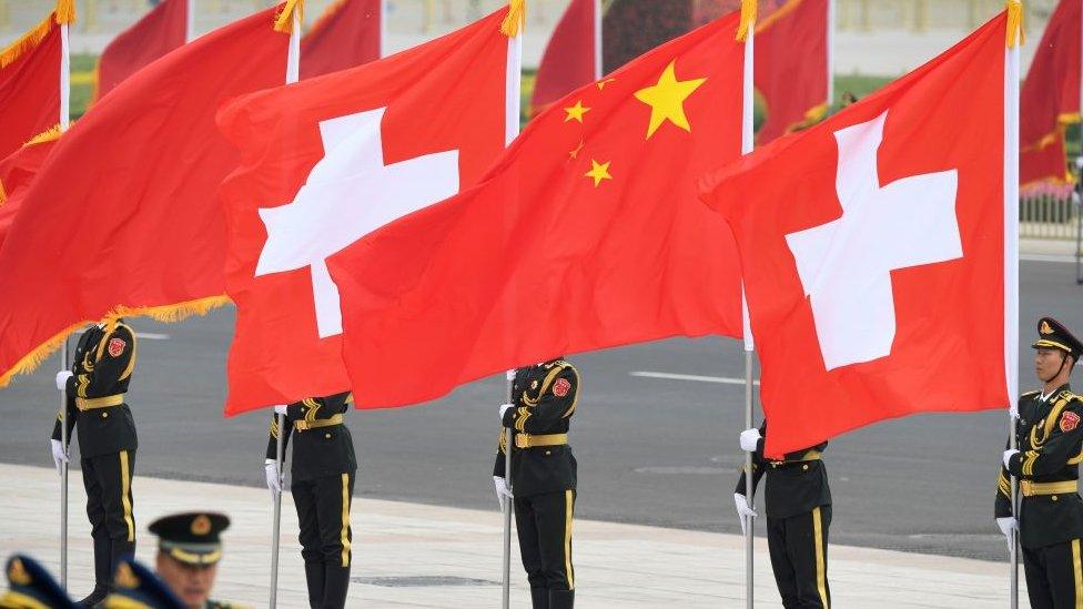 Chinese honour guards stand with Swiss and Chinese flags