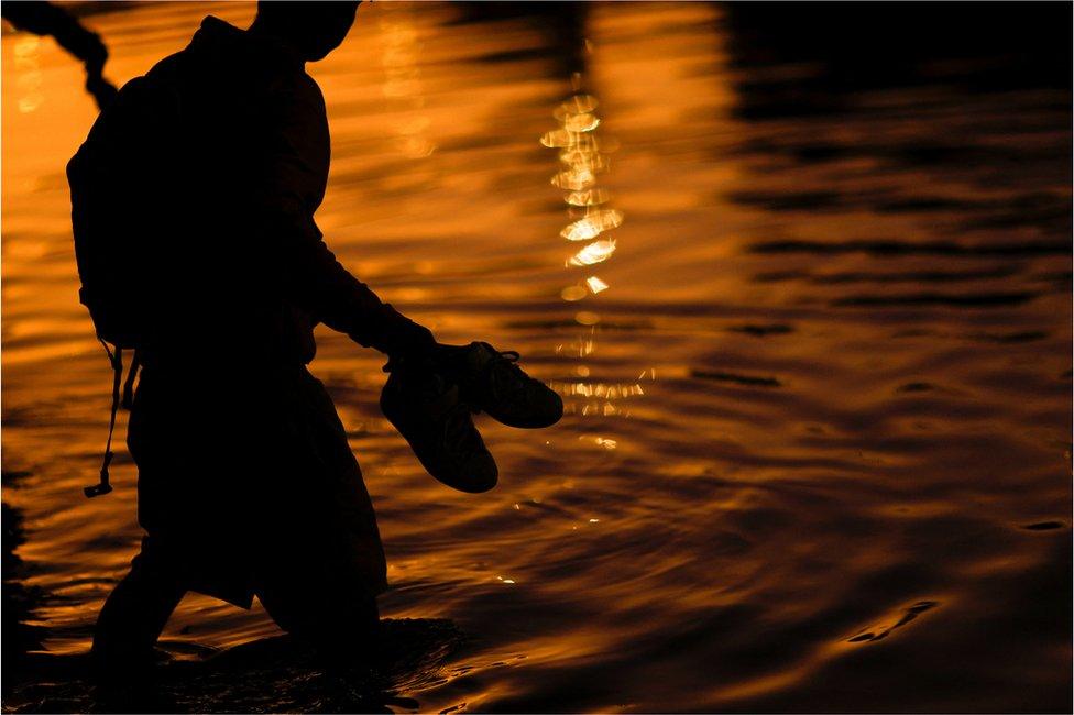 An asylum-seeking migrant crosses the Rio Bravo river, the border between the United States and Mexico, to request asylum in El Paso, Texas, U.S., as seen from Ciudad Juarez, Mexico December 21, 2022.