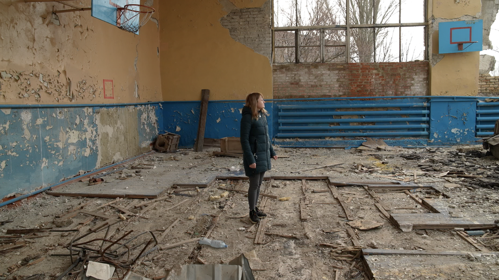 Mariya surveys a destroyed gym hall