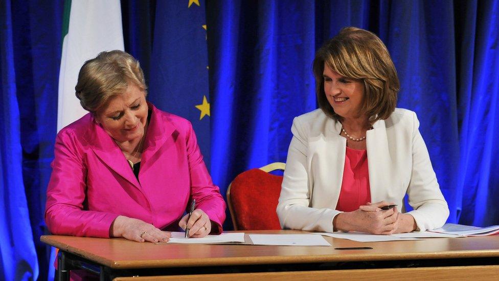 Irish Minister for Justice Frances Fitzgerald (L) signs the commencement order for the Marriage Act 2015 in front of Deputy Prime Minister (Tanaiste) Joan Burton