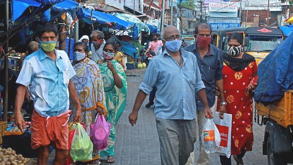 People shop at a vegetable and fruit market amid Covid-19 coronavirus pandemic in Kochi on May 7, 2021