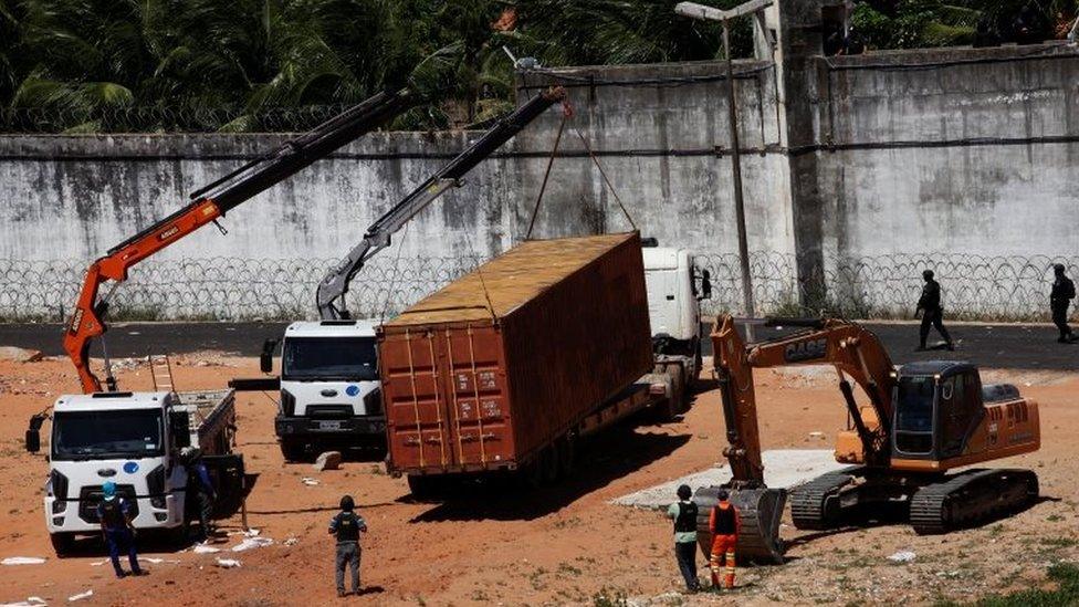 Workers place a container to separate two factions of drug gangs during an uprising at Alcacuz prison in Natal, Rio Grande do Norte state, Brazil, January 21, 2017