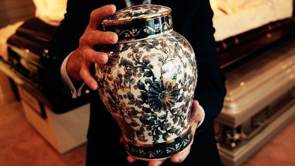 A man holds an ornate urn (FILE PHOTO)