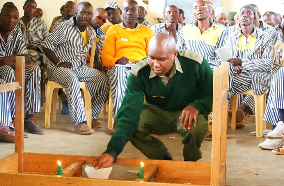 A prison guard burns paper with negative emotions written on