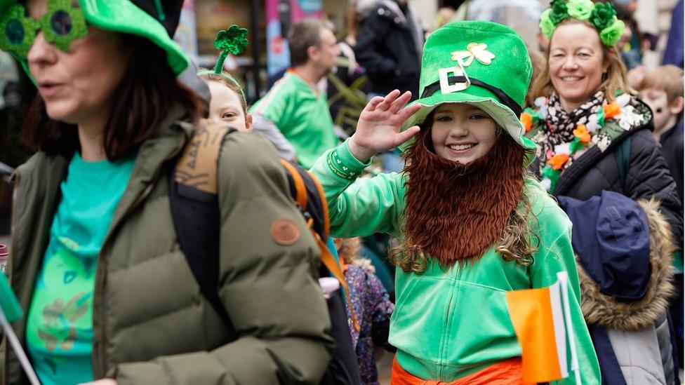 Person wearing green hat and beard. Also dressed in a green tracksuit.