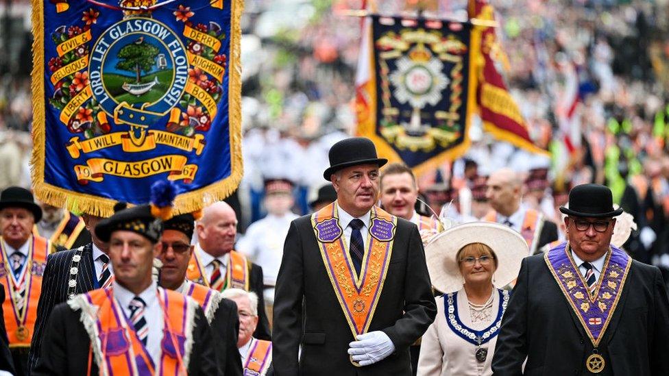 Members of the Orange Order and their supporters march through the city