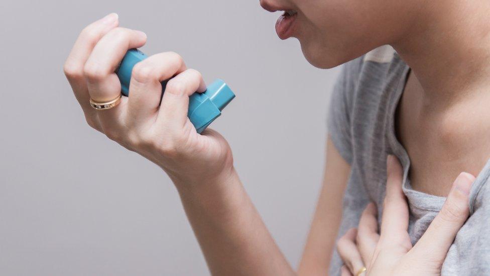 Woman using an asthma inhaler