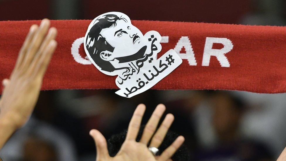 Qatari football fans hold picture of Emir Sheikh Tamim bin Hamad Al Thani saying: "All of us are Qatar" at a football match in Doha (13 June 2017)