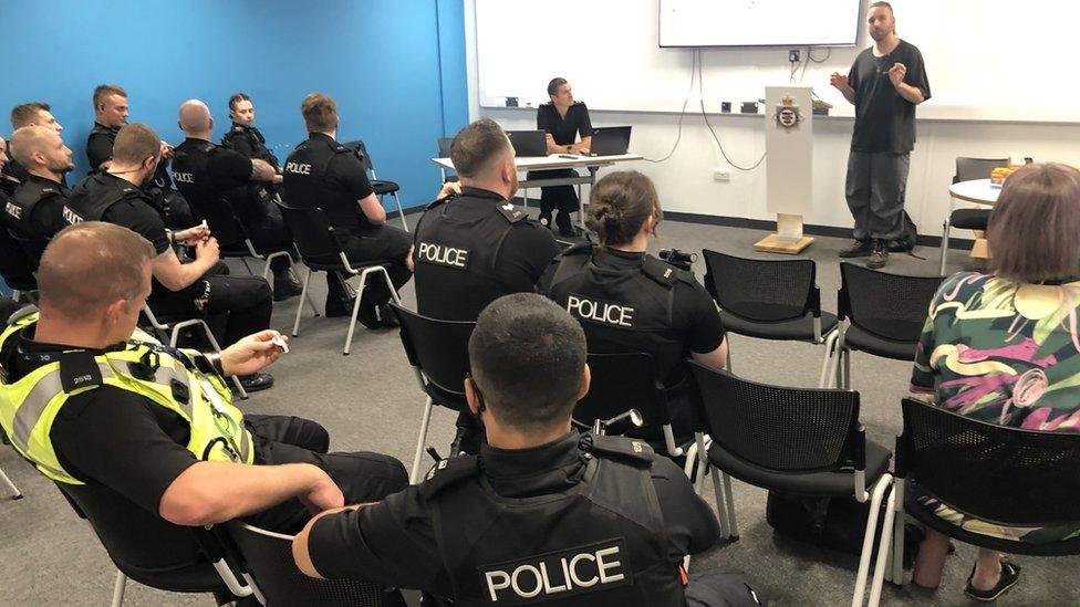 A group of police officers in black uniform receiving training