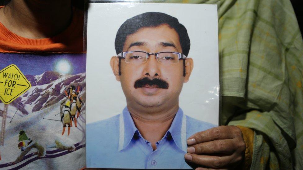 Close up on hands holding a photo of Sajidul Islam Shumon