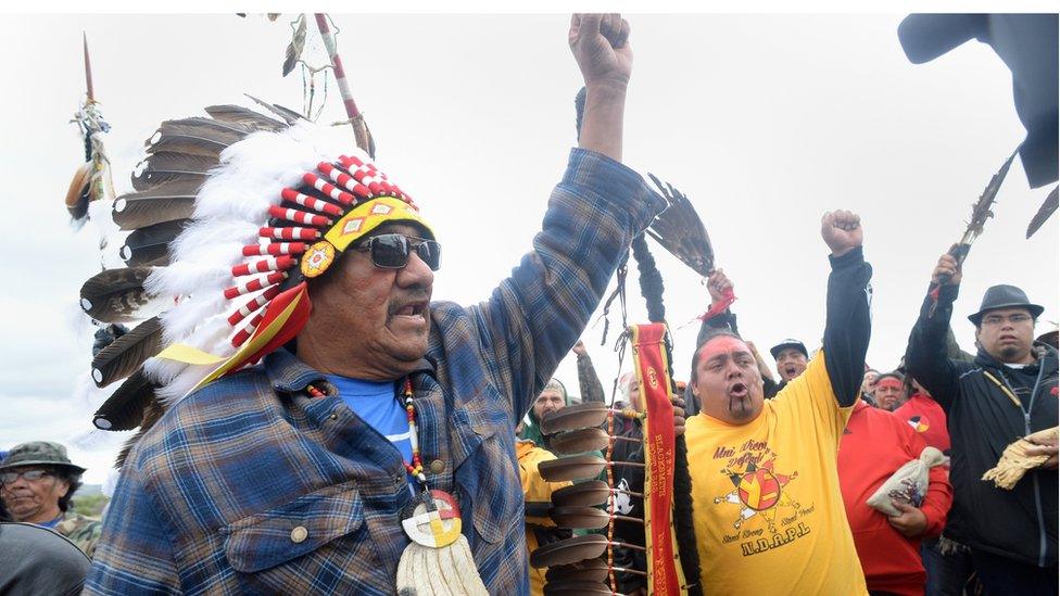 JR American Horse, left, raises his fist with others while leading a march to the Dakota Access Pipeline site in southern Morton County North Dakota on 9 September 2016