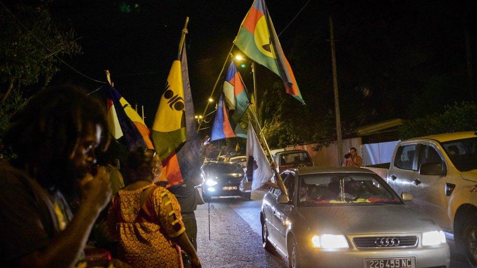 Activists display their flags in front of the pro-independent Union Caledonienne (UC) following the referendum on New Caledonia"s independence on November 4