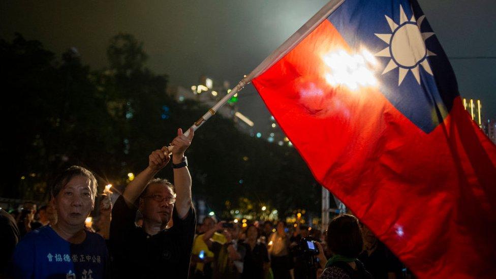 A man is seen waving a Taiwan flag during a vigil in Hong Kong, China. 4 June 2019