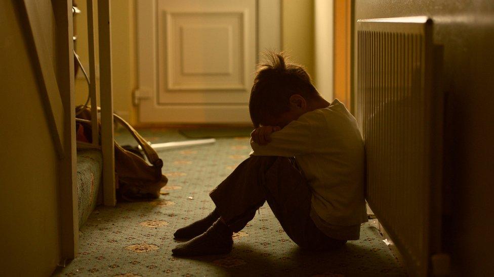 Upset child sitting in hallway