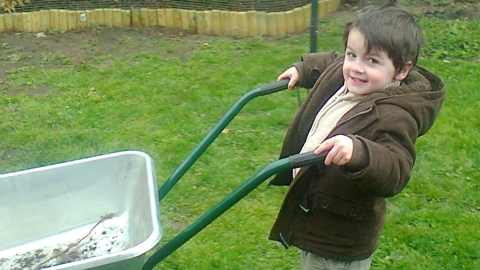 Cameron Mathieson pushes a wheelbarrow