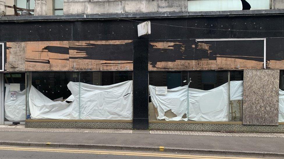 Boarded up windows of an old Hyper Values store