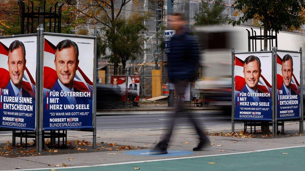 A man passes presidential election campaign posters of far right Freedom Party (FPOe) presidential candidate Norbert Hofer in Vienna, Austria