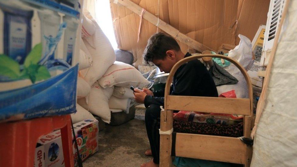 Grandson of displaced Yazidi Nayef al-Hamo plays with his mobile before leaving his home in Sharya town and heading back to Sinjar following the outbreak of the coronavirus and economic crisis, near Dohuk, Iraq July 3, 2020