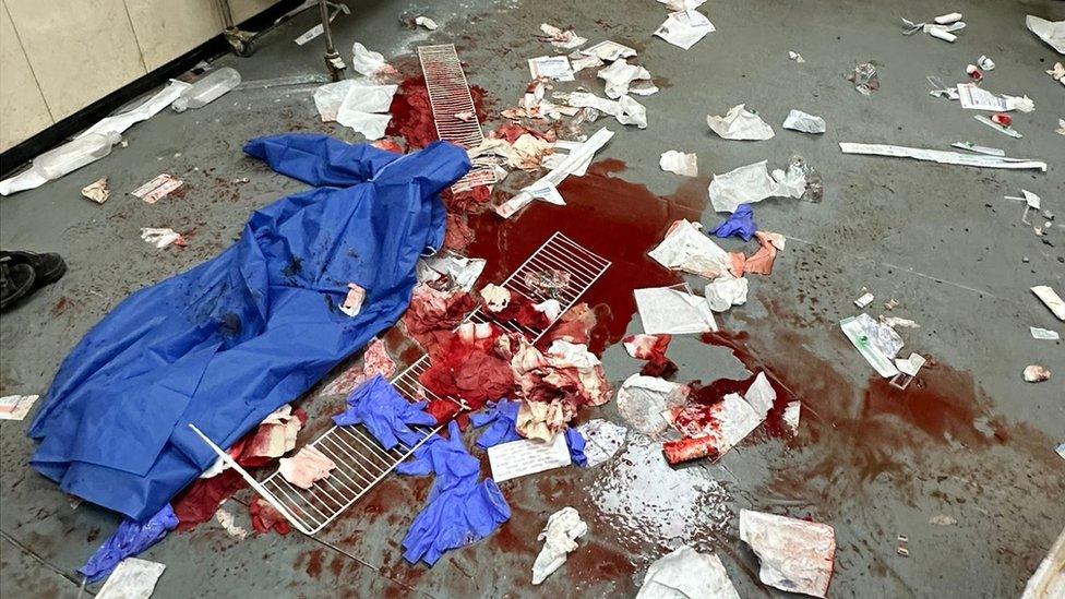 Medical equipment and blood pictured on the floor of al-Aqsa Hospital