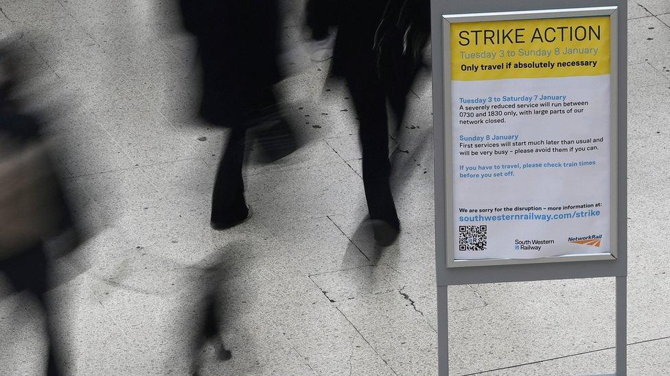 Travellers walk past an information board, as rail workers continue a strike over pay and terms, Waterloo Station in London, Britain, January 3, 2023