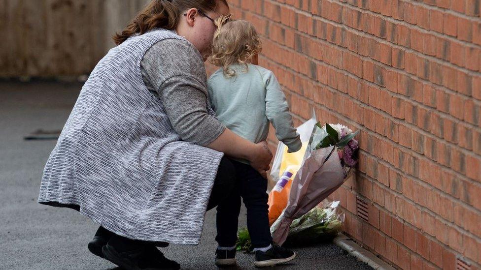 A woman and child laying flowers