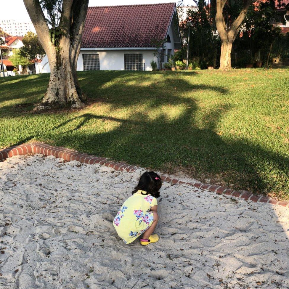 Alex playing in a sandpit.