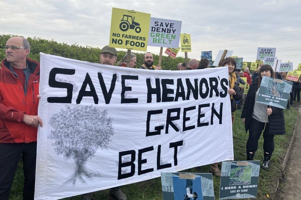 Protesters gather with placards and banners