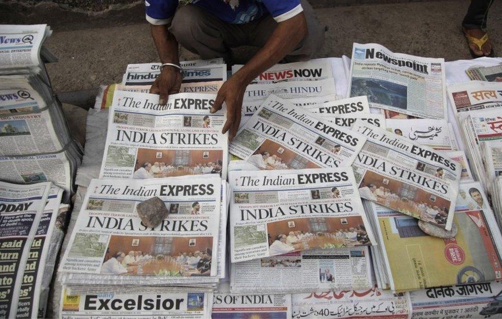 A newspaper vendor arranges morning newspapers carrying headlines of India"s military strikes, in Jammu, India, Friday, Sept. 30, 2016.