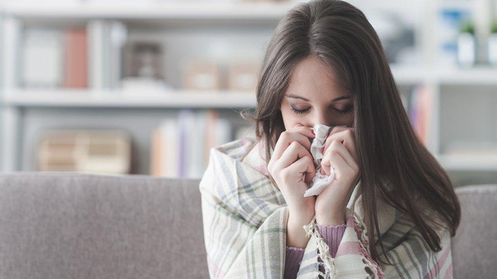 A woman blowing her nose