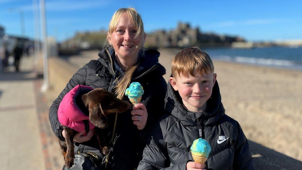 Woman and son smiling by Peel beach with blue and yellow ice creams