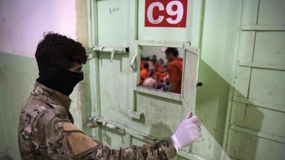 A member of the Syrian Democratic Forces (SDF) stands guard in a prison where men suspected to be affiliated with the Islamic State (IS) group are jailed in northeast Syria