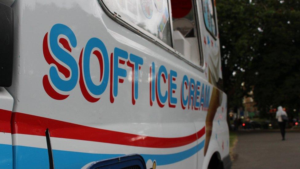 An ice cream van keeps selling despite the rain in Clapham Common, South London