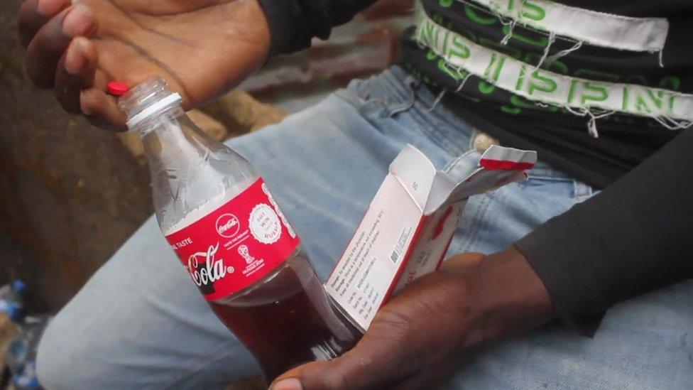 A man putting a Tramadol pill into a bottle in Nigeria