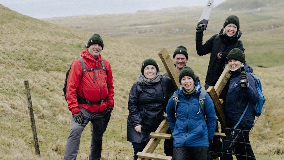 Green Group members pose with finished steps over a fence