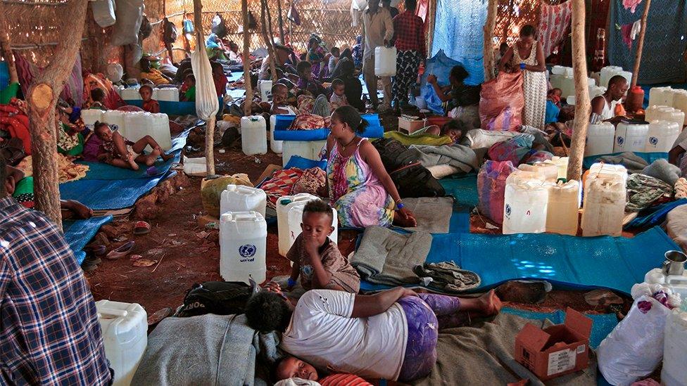 Ethiopian refugees who fled fighting in Tigray province gather in a hut at the Um Raquba camp in Sudan's eastern Gedaref state, on November 18, 2020.