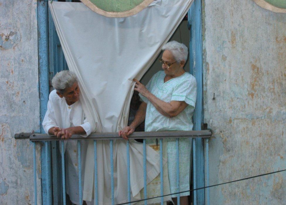 Two women behind a curtain