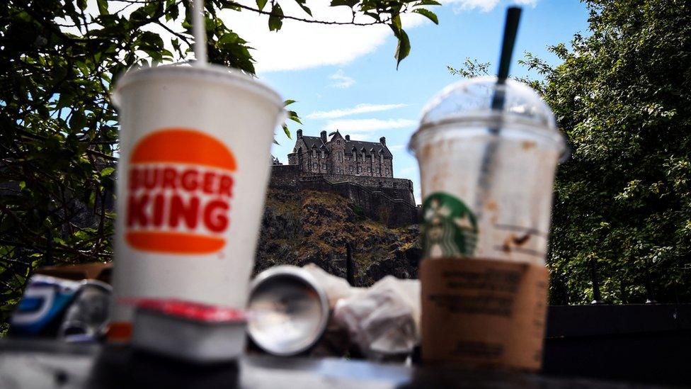 photograph shows rubbish piled on a table with edinburgh castle in the background