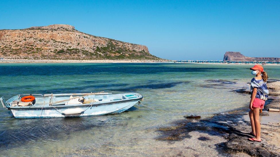 A girl wearing a mask on Balos beach in Crete, Greece