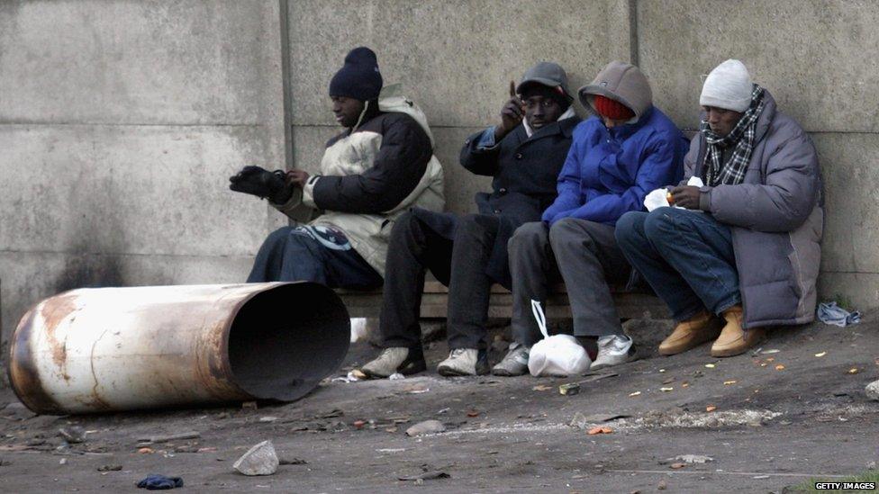 Four young men sitting on a bench