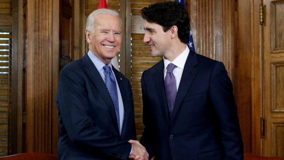 Canada's Prime Minister Justin Trudeau (R) shakes hands with US Vice President Joe Biden