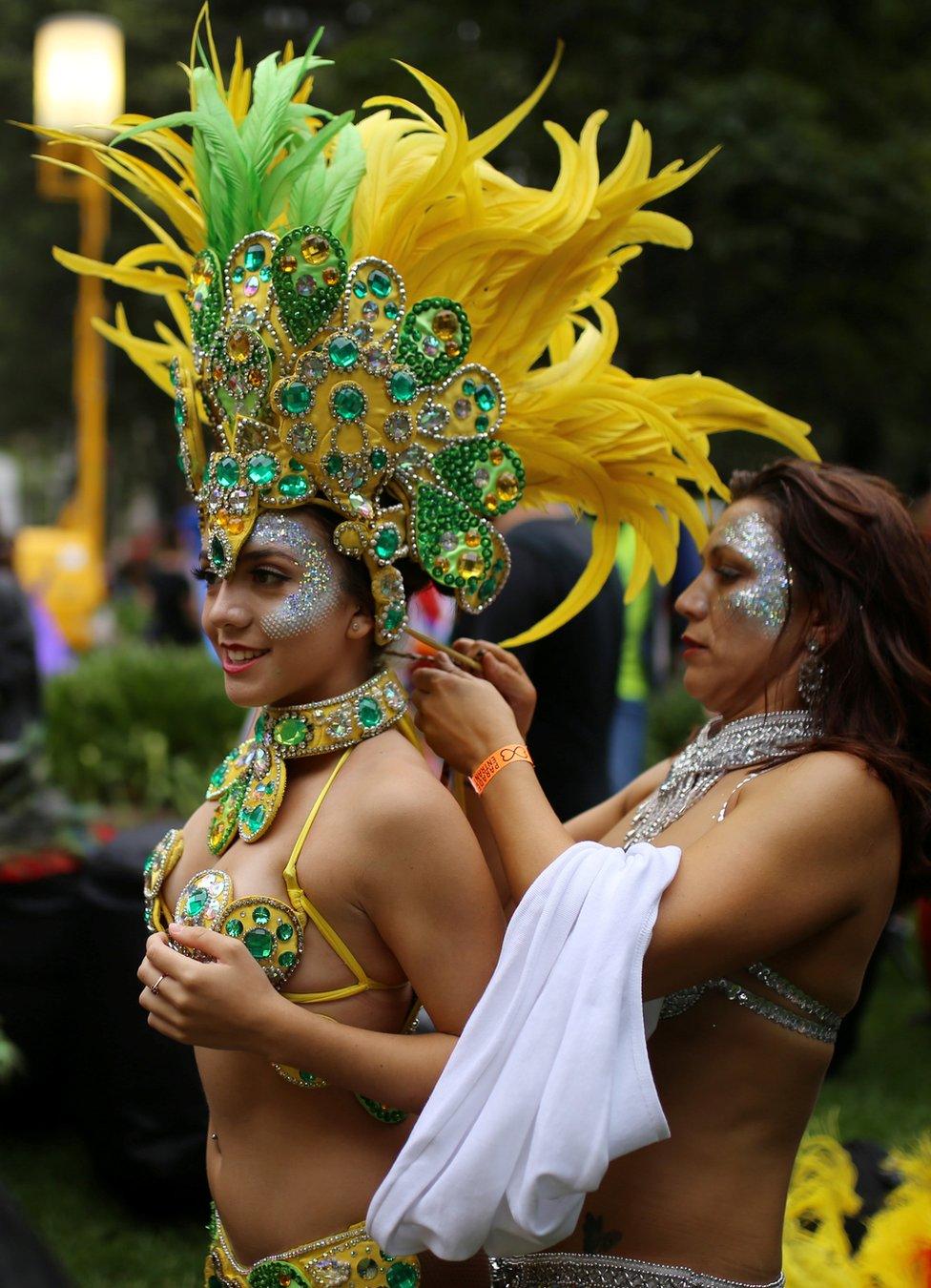 A woman in a bikini and elaborate yellow and green feathered headress and collar, in the annual Sydney Gay and Lesbian Mardi Gras festival prepares her costume in Sydney, Australia March 4, 2017