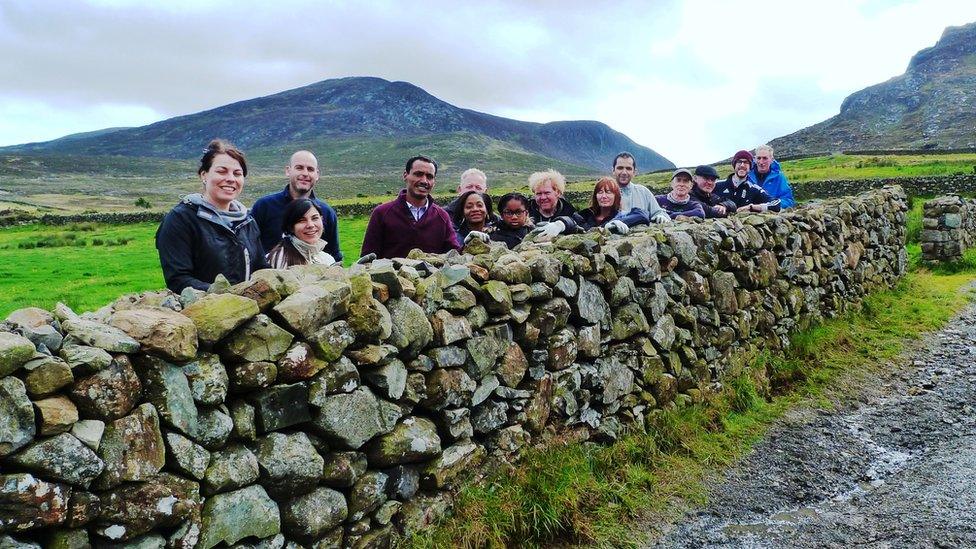 Volunteers pictured next to a repaired dry-stone wall in the Mournes