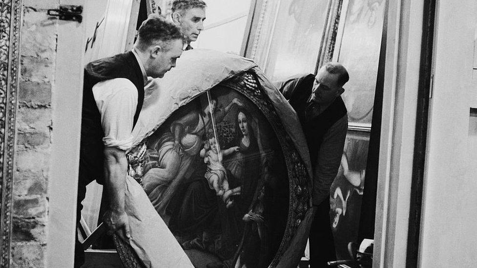 September 1942: Attendants take the painting 'Mother and Child', of the Botticelli school, out of storage for routine inspection in a subterranean chamber at Manod Quarry, north Wales