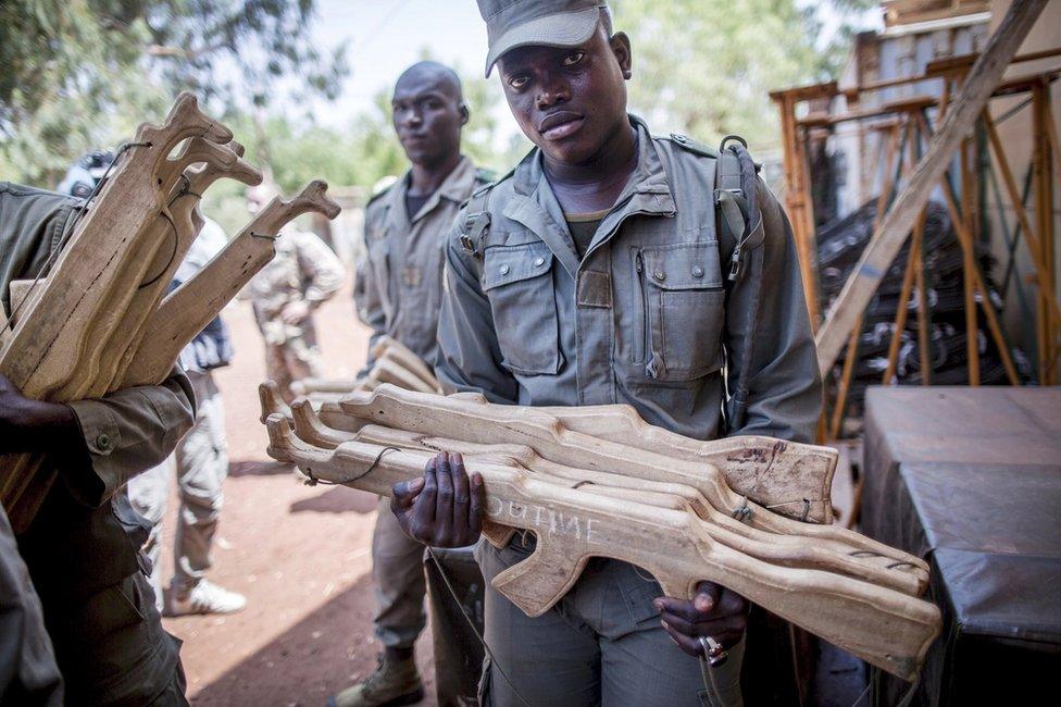 A Malian soldier carries wooden training guns at the European Union military training centre in Koulikoro, Mali - Wednesday 6 April 2016