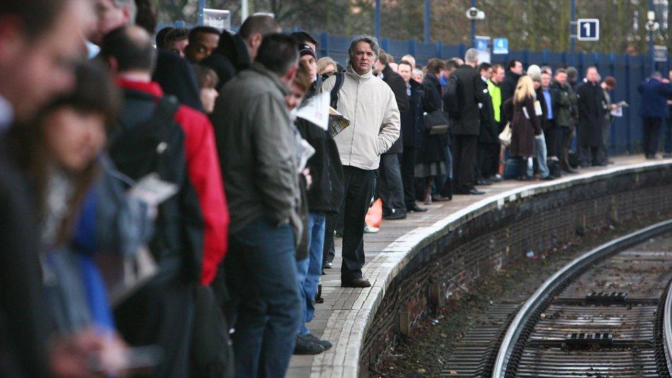 People waiting for trains on a platform